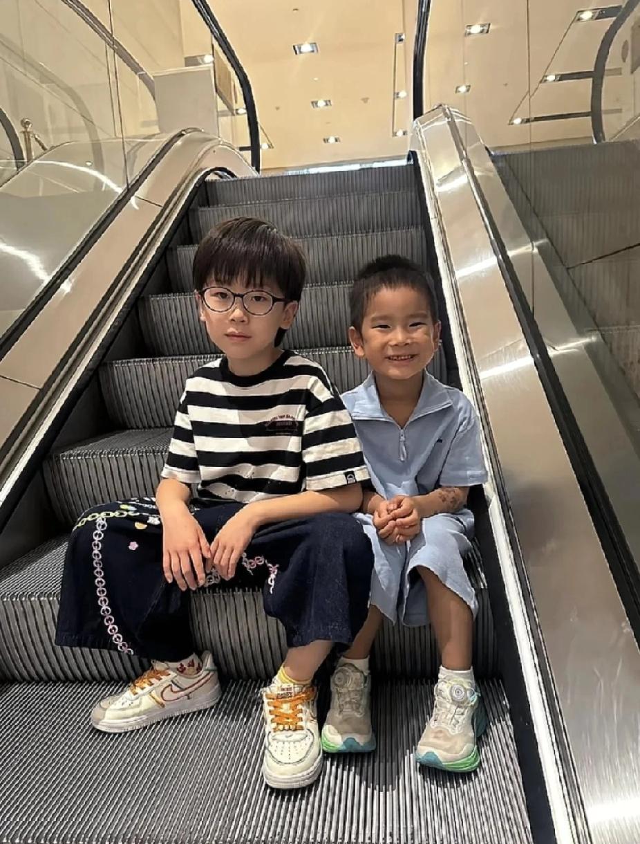被梁靖崑家俩小孩可爱到啦！哥哥戴着眼镜，一身条纹上衣搭配休闲长裤，安安静静，透着