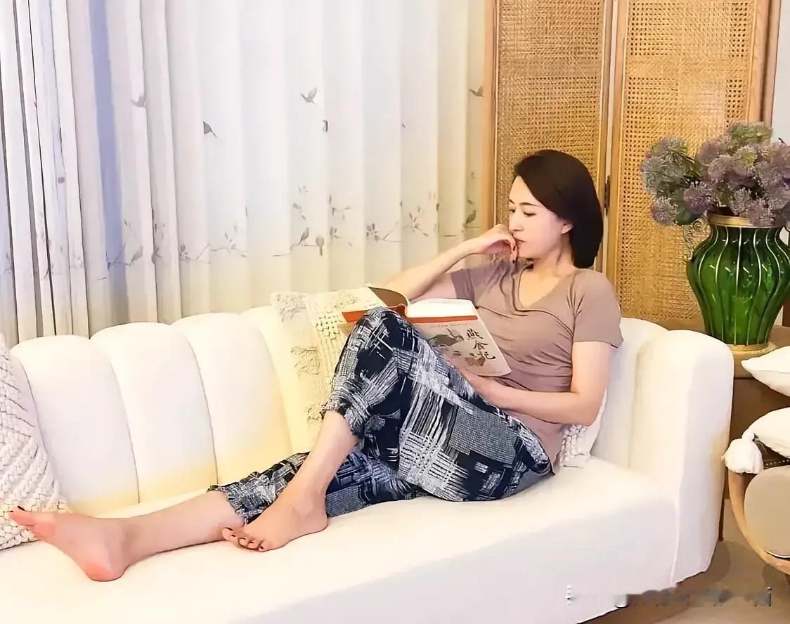 离开央视后的张蕾，在家沙发上看书，虽不化妆，衣服穿的简约，风采依旧，魅力不减当年
