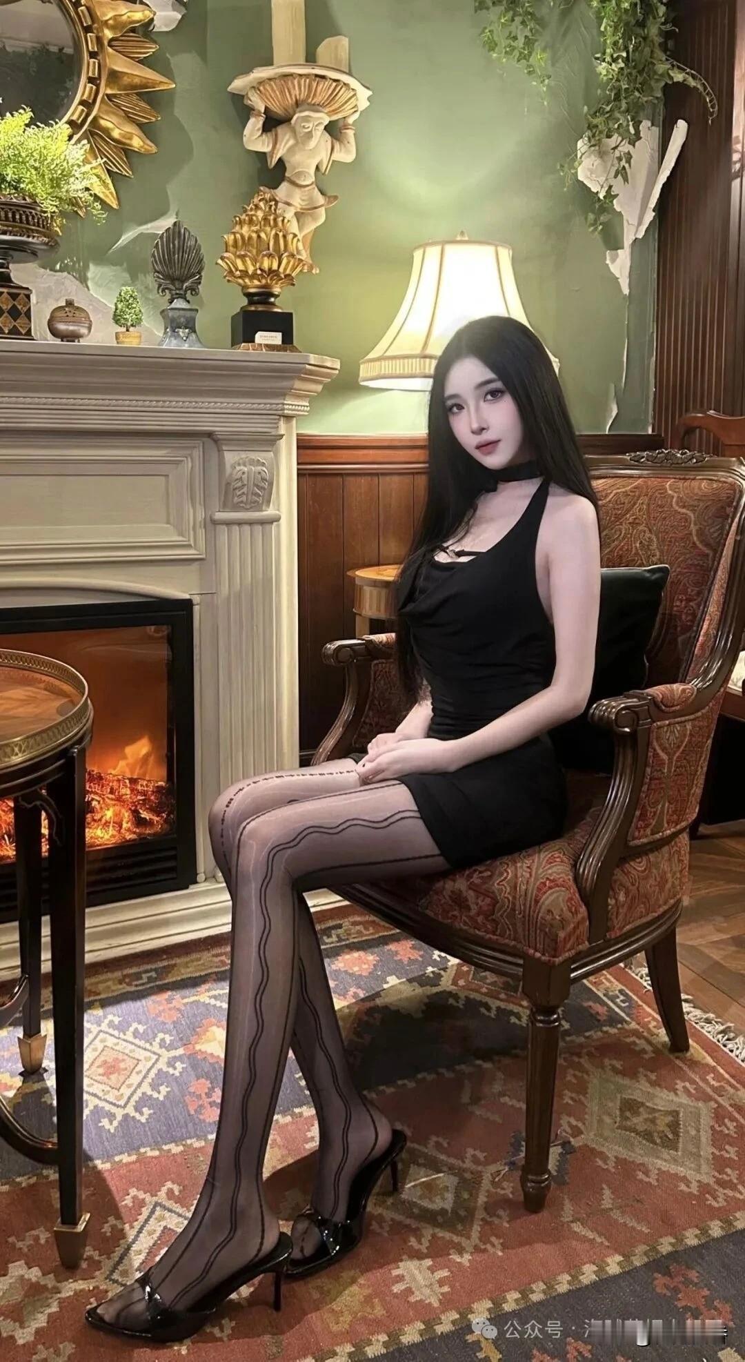 优雅黑裙与复古壁炉的完美结合，尽显时尚与古典的魅力。