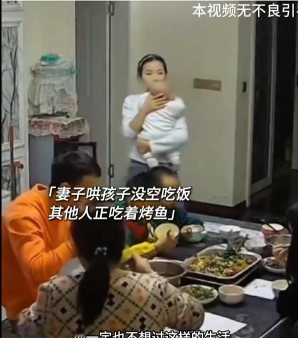 如果可以选择，
她一定不会过这样的生活，
一家人坐在桌子吃饭，女子自己抱孩子，饿