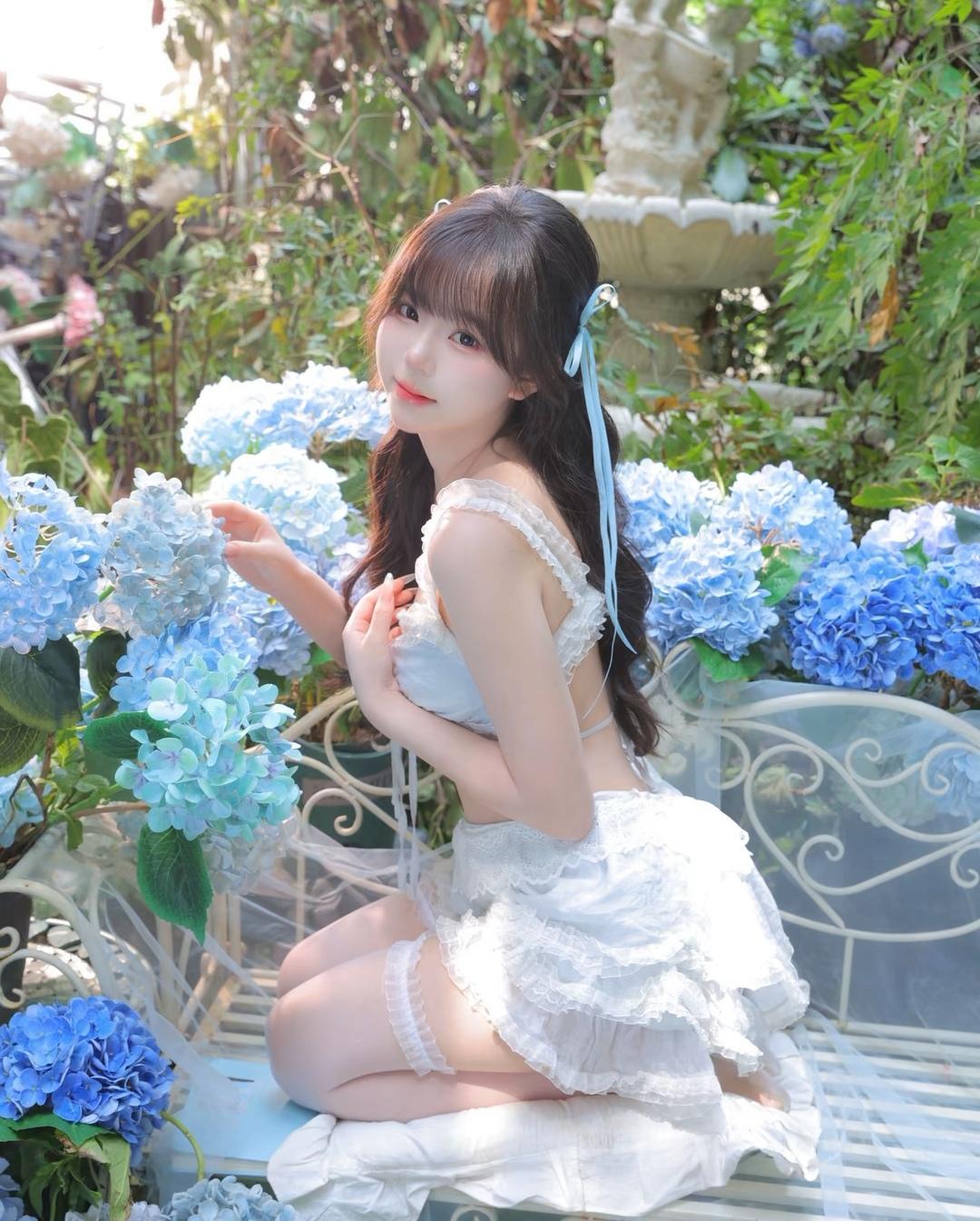 梦幻花园中的少女，蓝色绣球花与白色蕾丝裙的完美搭配，仿佛童话中的场景。