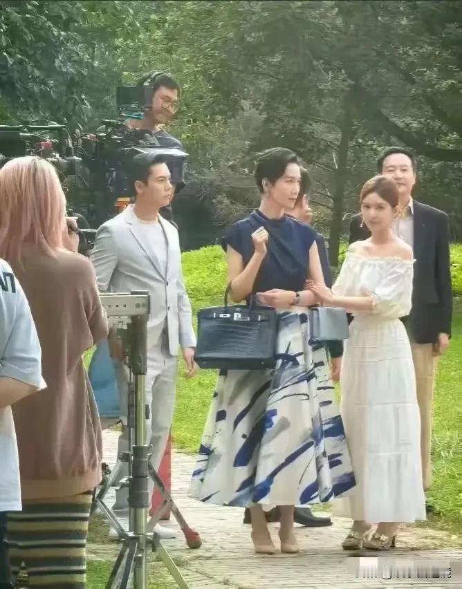 感觉照片中挎着包包这个女人气场好强大，高冷又严肃，娇小的赵露思在她面前被秒的剩下
