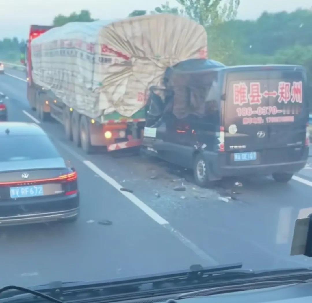 高速路上一辆黑色睢县至郑州小客车撞上大货车。（行驶高速，保持车距）