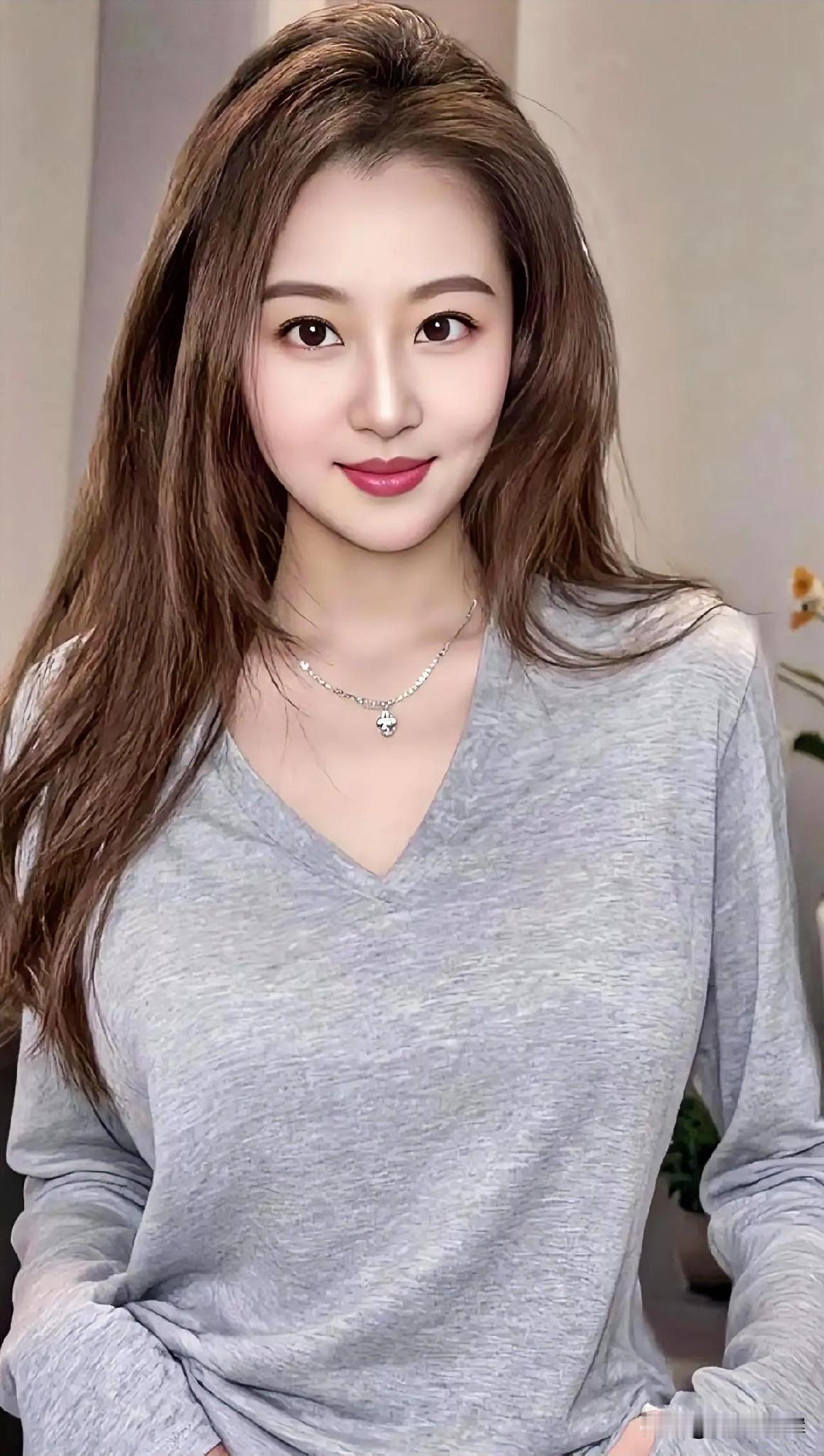 发梢流转柔光，

眼眸盛着星芒。

浅灰衣袂轻扬，

颈间银链微晃。

唇角漾开