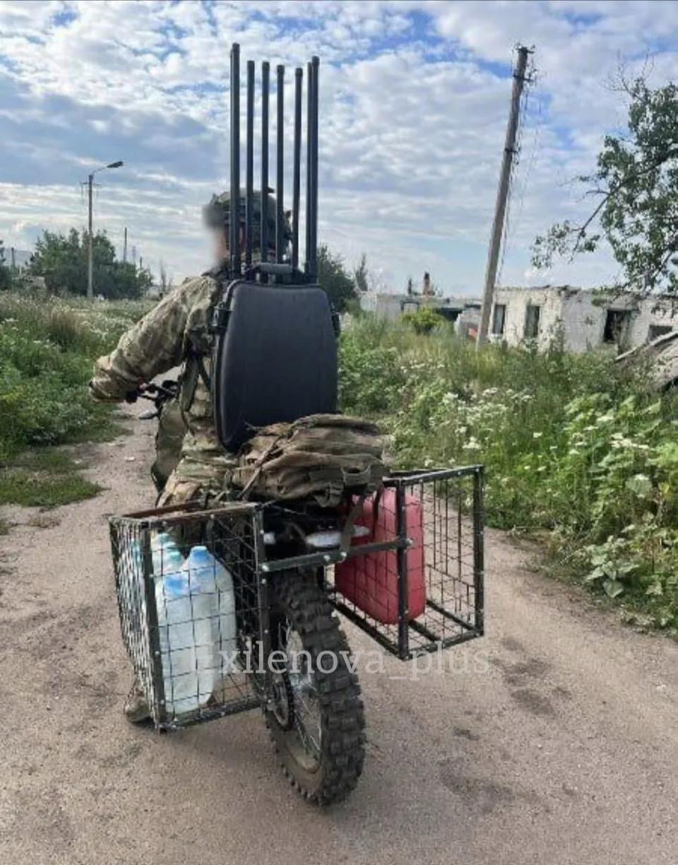 俄军士兵在前线用摩托车送水都要背上反无人机干扰装置（多根干扰天线是为了覆盖尽可能