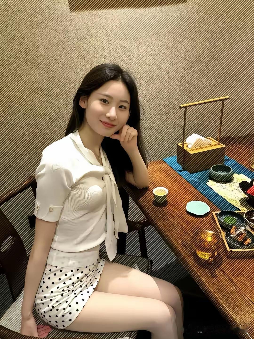 一位女生坐在餐桌旁，微笑着看镜头。如何给女友拍性感和可爱的照片 穿牛仔短裤拍照,