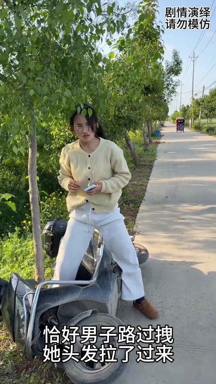 女子坐电车看手机时翻倒了，路过男子拉着她头发拽过来了。
女子坐在电车上玩手机，旁