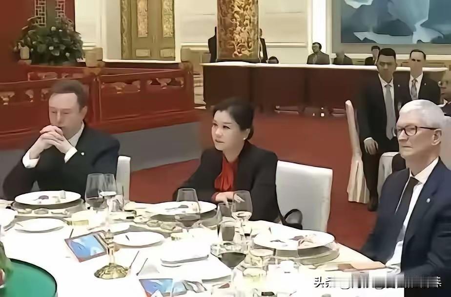 很多人好奇坐在马斯克和库克中间的女人是谁？她叫周群飞，1970年出生于湖南湘乡，