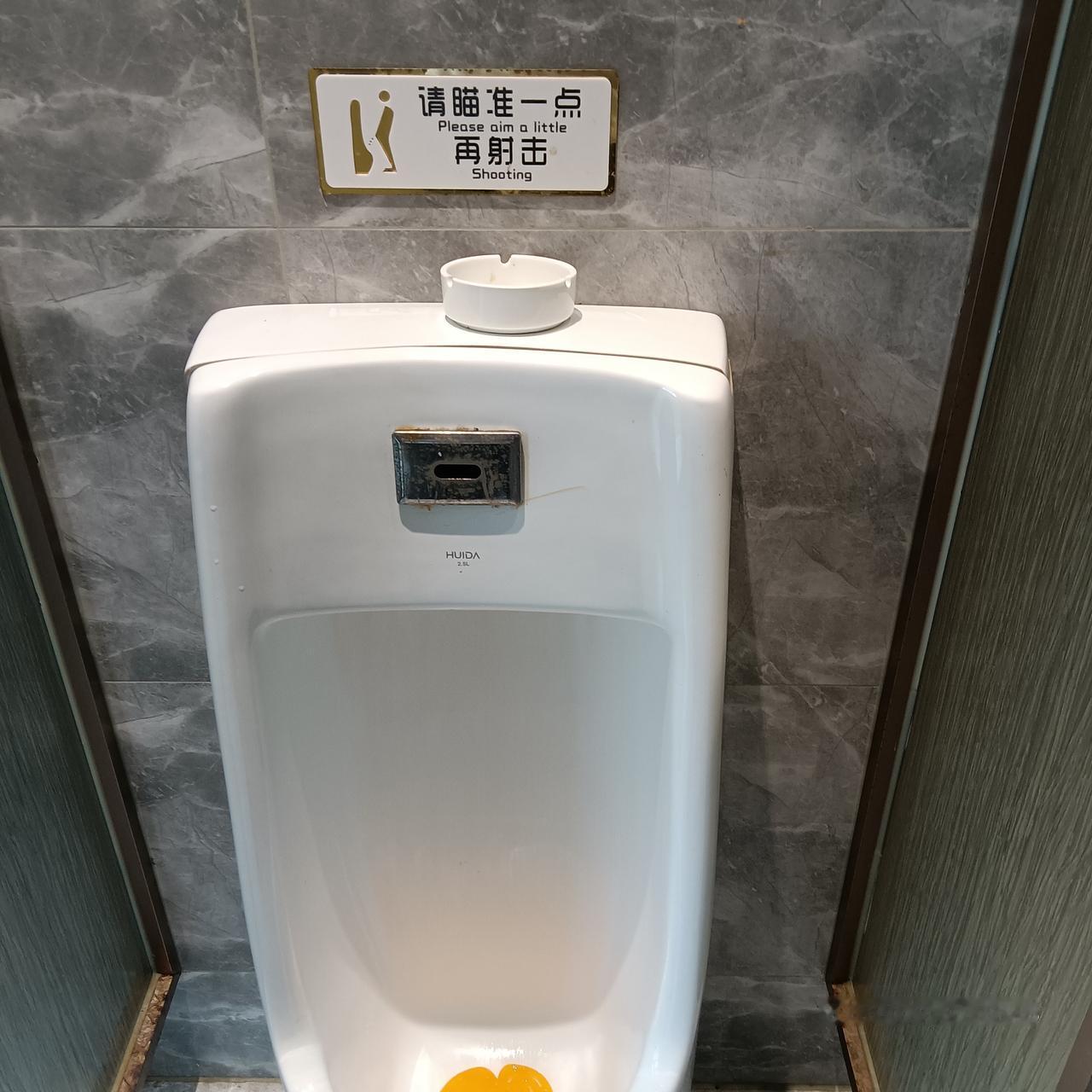今天在希尔顿吃了一顿饭，中途上厕所，恰巧遇到图中的标语——“请瞄准一点再射击”，