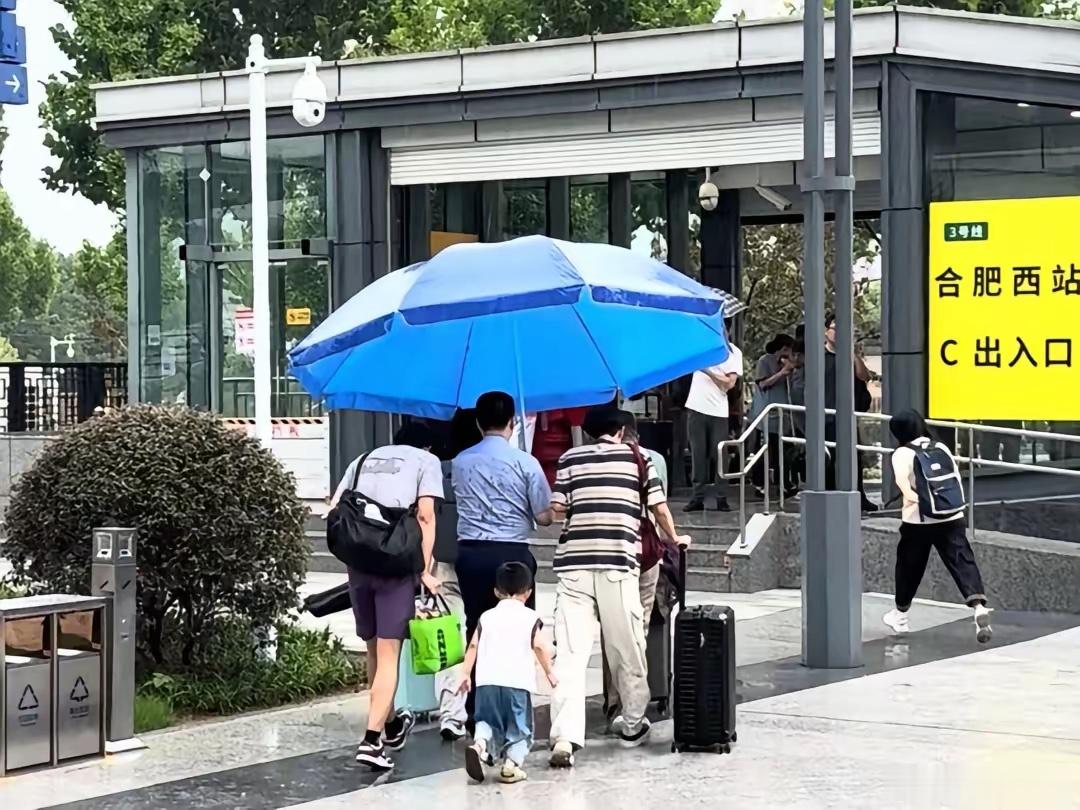 合肥大雨轨道工作人员撑大伞接乘客今日中午时分，合肥突遇短时强降雨天气，城区多地雨