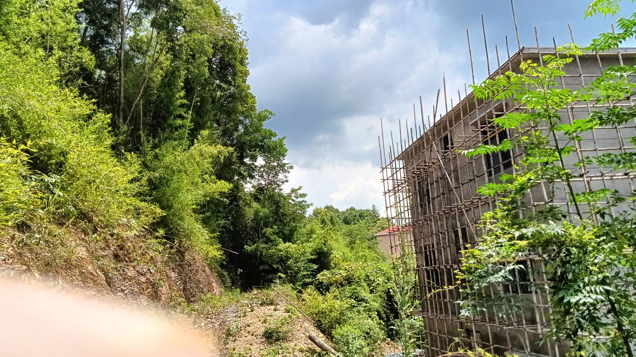 农村有句俗话，石头上不能生根，这家人起初不信，用挖机把山体凿开便建房了，不信的事