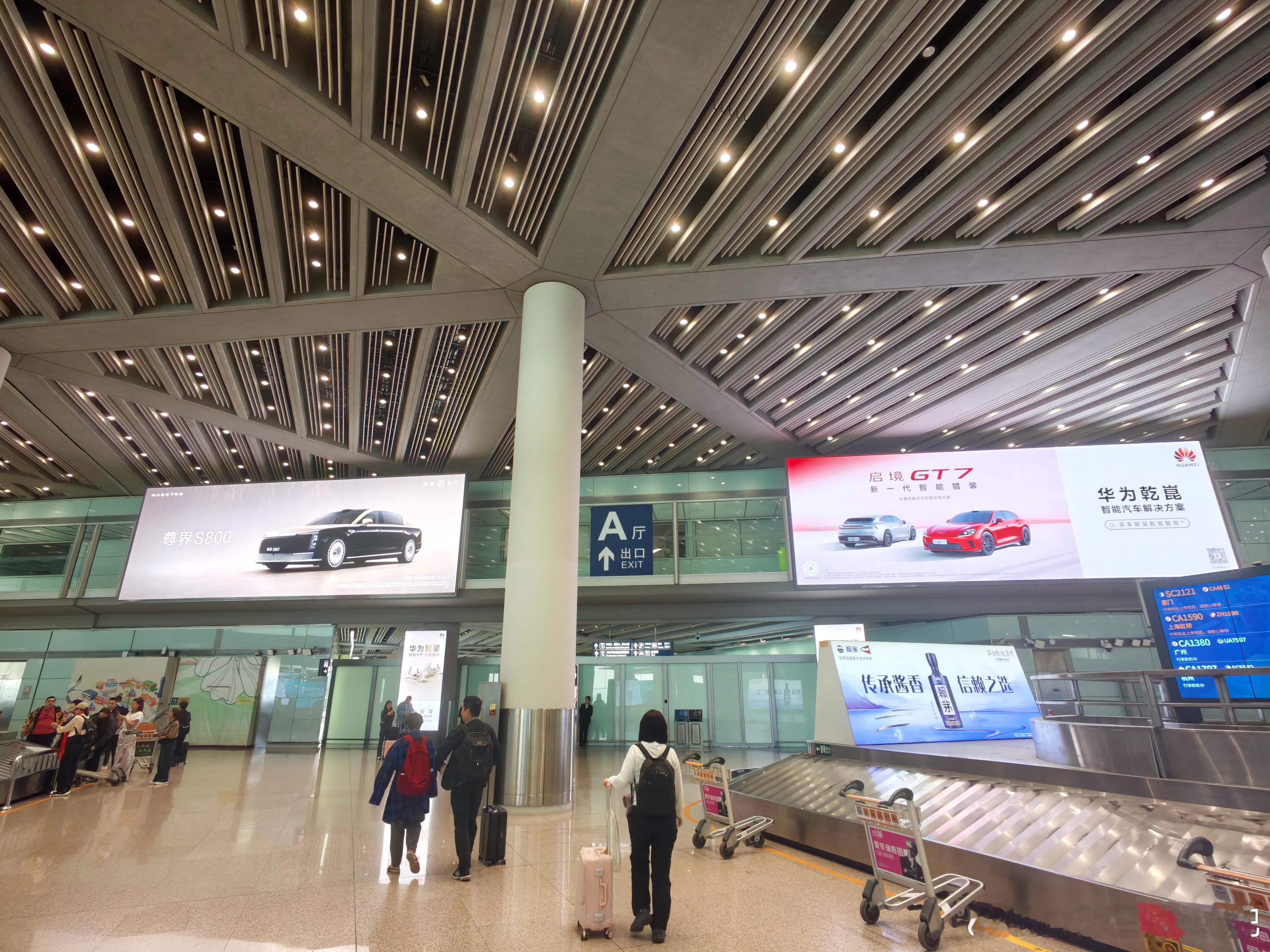 首都机场的境界齐聚，下面还有个华为Drive ONE电驱的广告牌。 