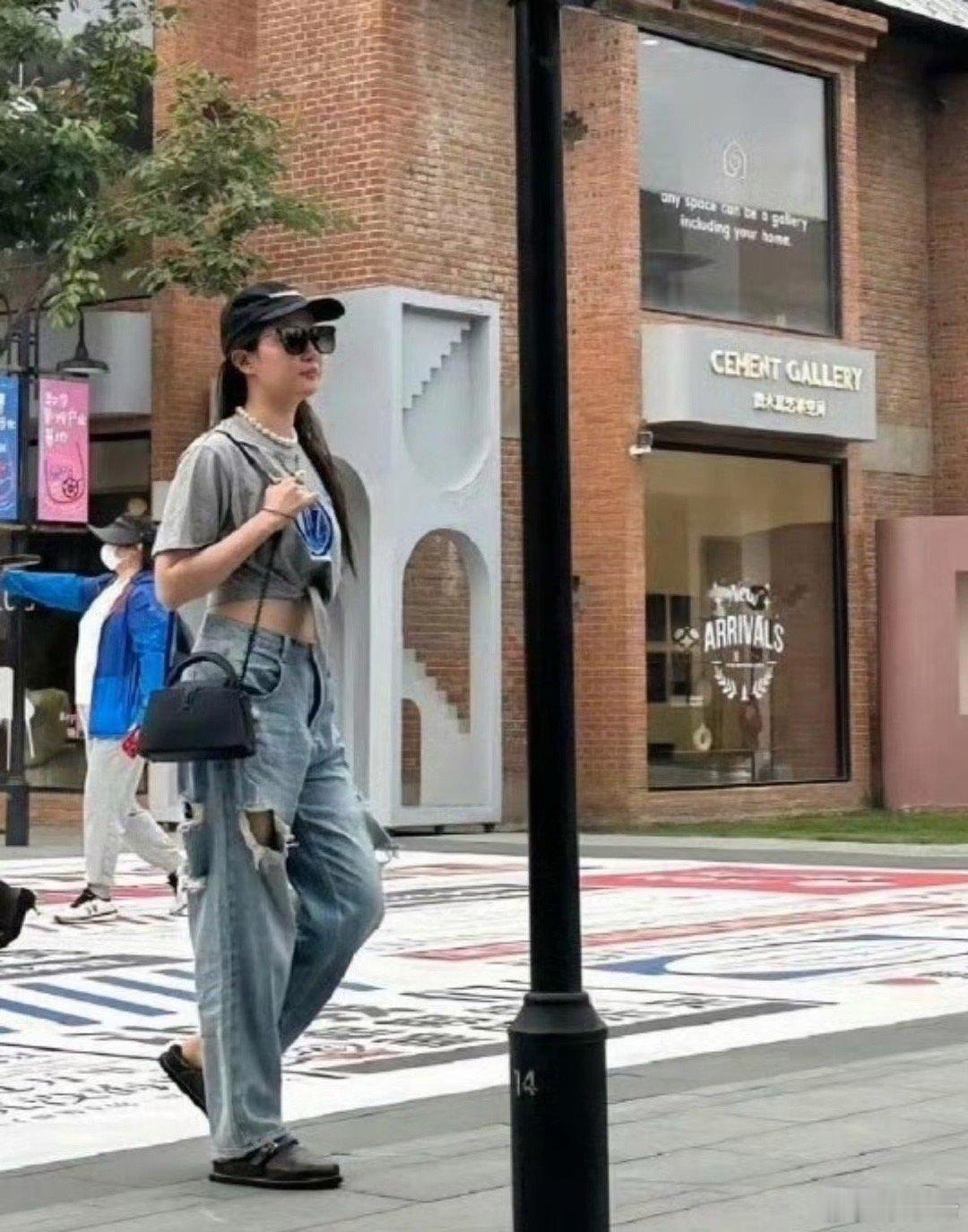 网友在街头偶遇刘亦菲和朋友一起逛街，穿着破洞牛仔裤，戴着棒球帽，休闲又时尚，本人