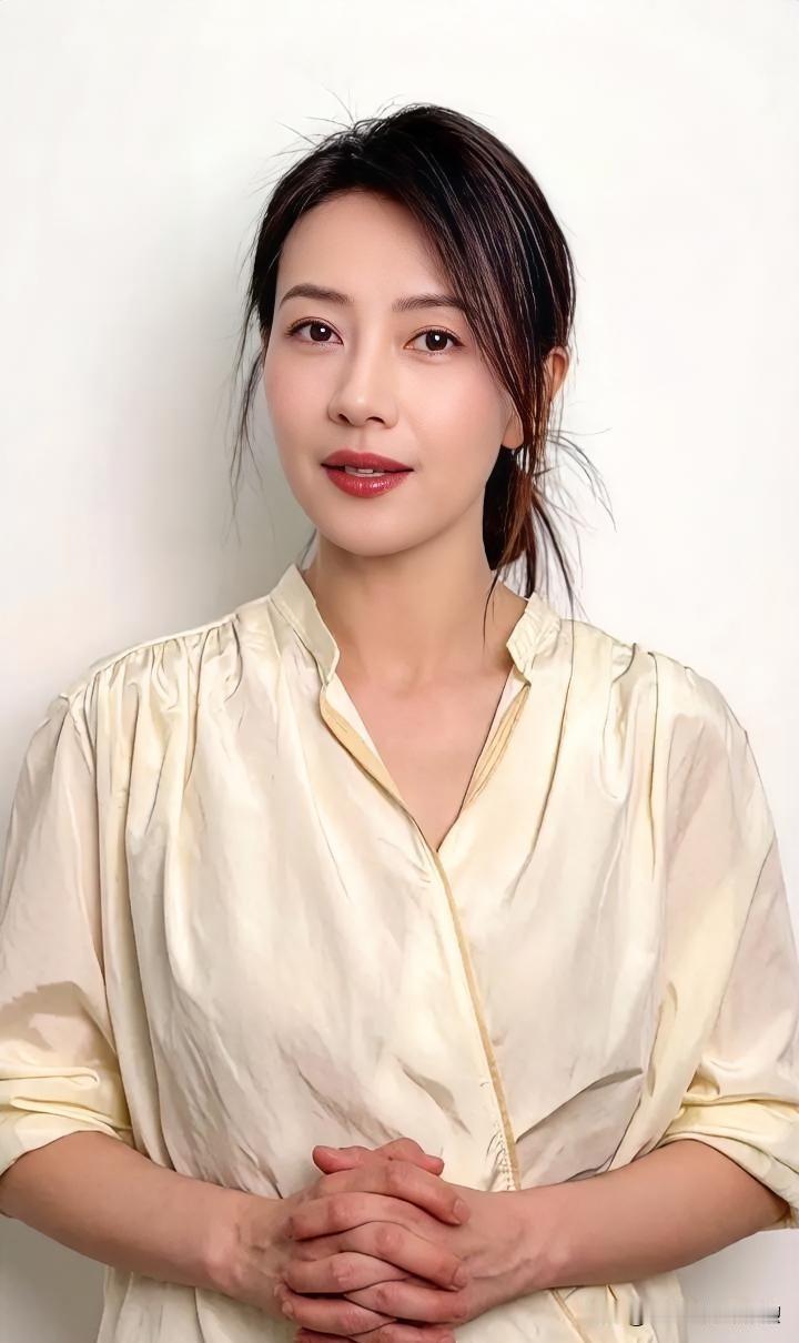 素衣如月凝清光，青丝微挽透温婉。

玉手交叠藏雅意，眸含春水映晴光。

淡颜素韵