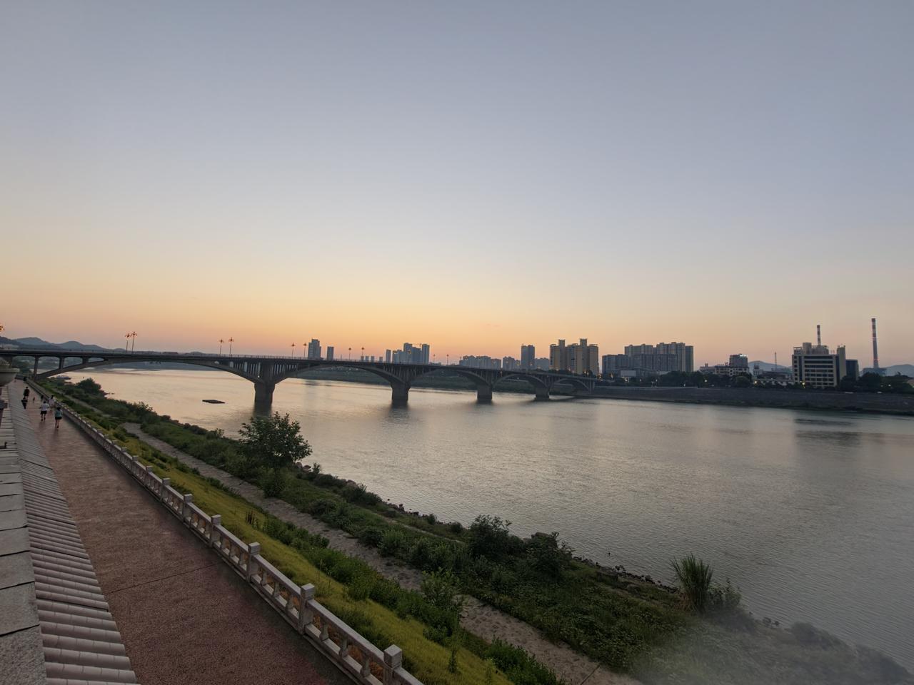 山城石门，天刚破晓。
大桥的橘色路灯还在静静亮着，微光洒向缓缓流淌的江水。
天边