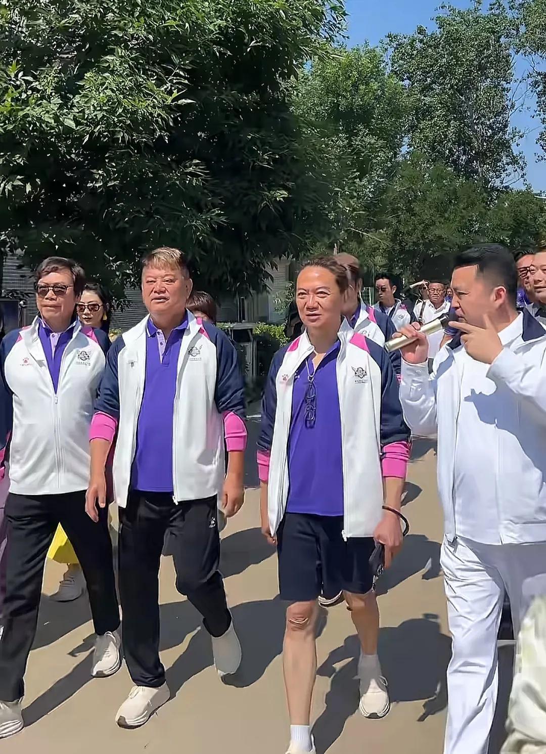 74 岁的陈百祥背手踱步在河北衡水的乡间小路上，身后跟着二十余位精心搭配紫白队服