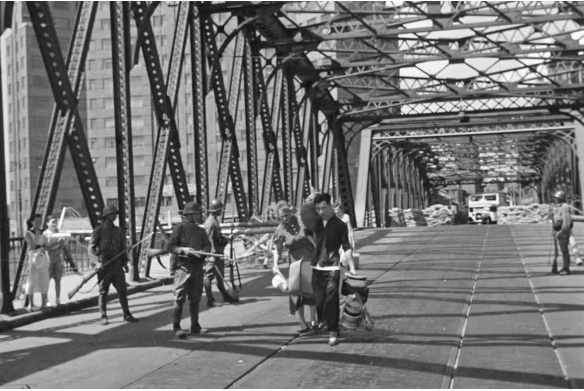 1937年上海，淞沪会战期间，日军占领外白渡桥桥，在桥上盘查来往的路人。