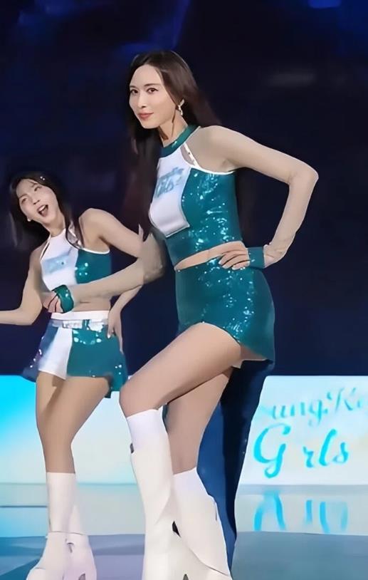 年过五旬姿韵娇，轻裁队服曳纤腰。
翩跹舞步风前旋，明媚眸光云外摇。
未许霜华侵鬓