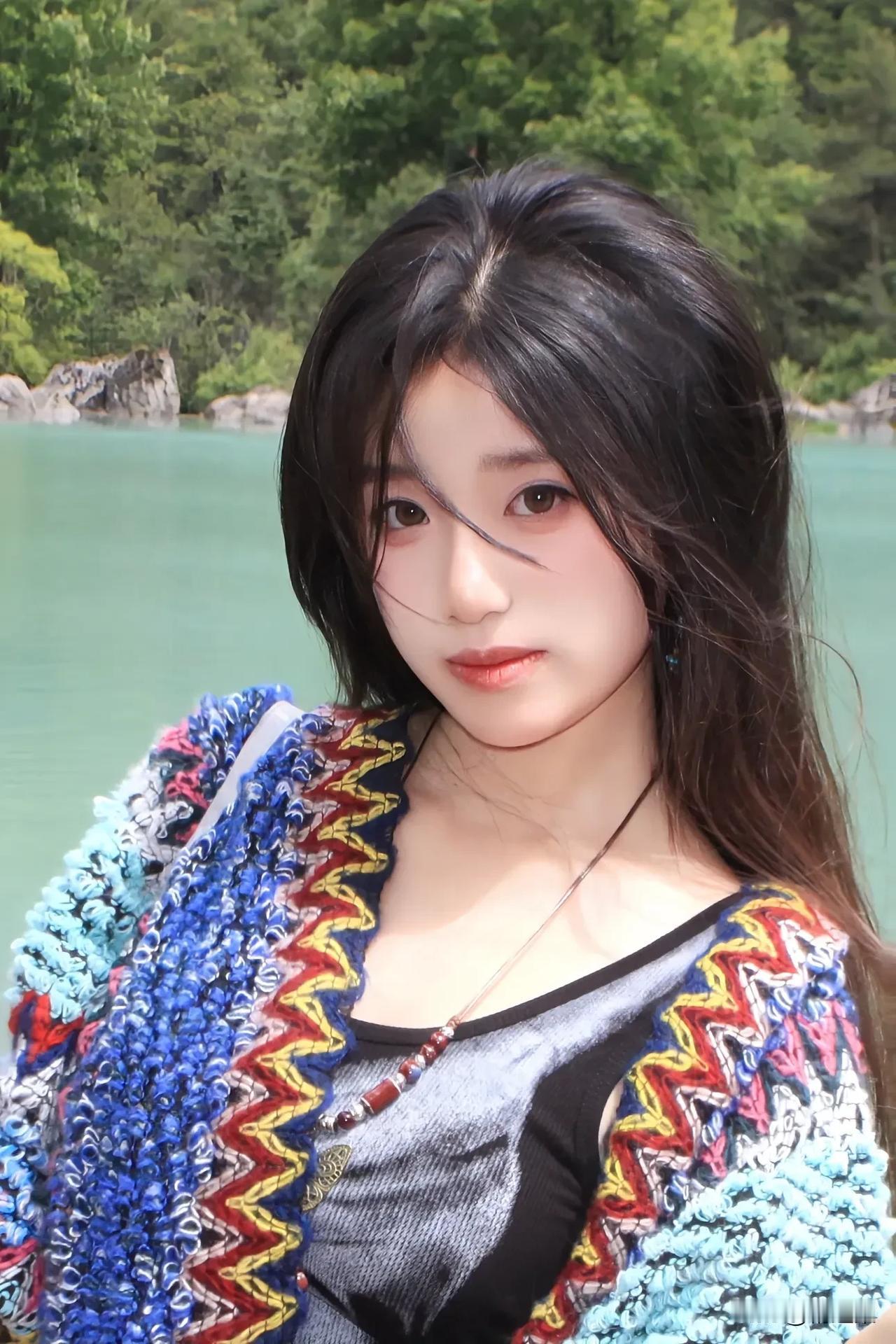 在碧绿湖水边，少女与自然相映成趣