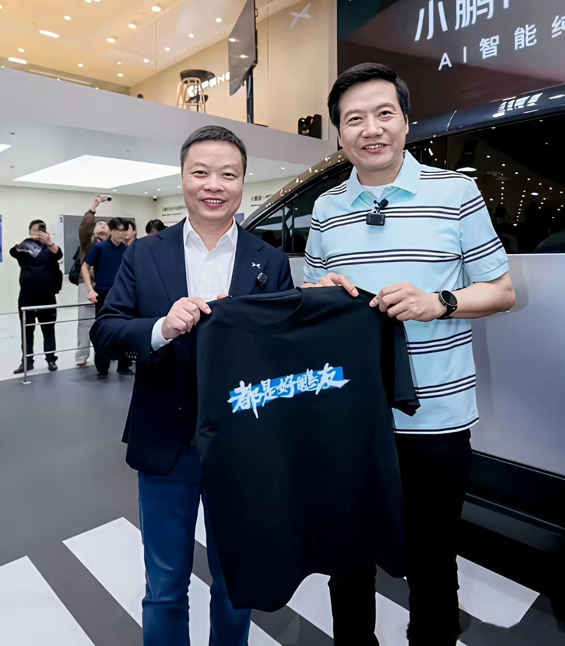 雷军在车展送带标语的体恤：送王传福的写着“在一起才是中国汽车”，送小鹏的写着“都