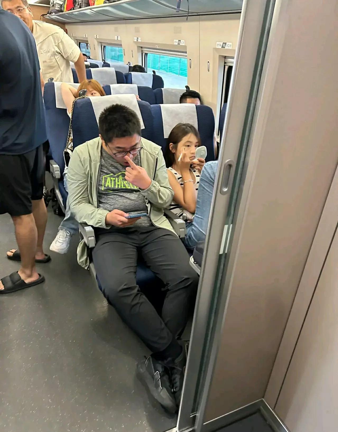 美女的坐姿实真是大大咧咧，旁若无人