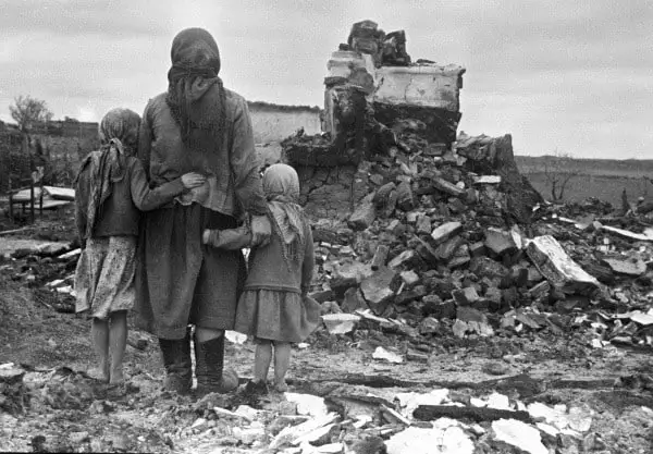1943 年 9 月 1 日，俄罗斯母亲和孩子们看着被毁坏的房屋。二战...