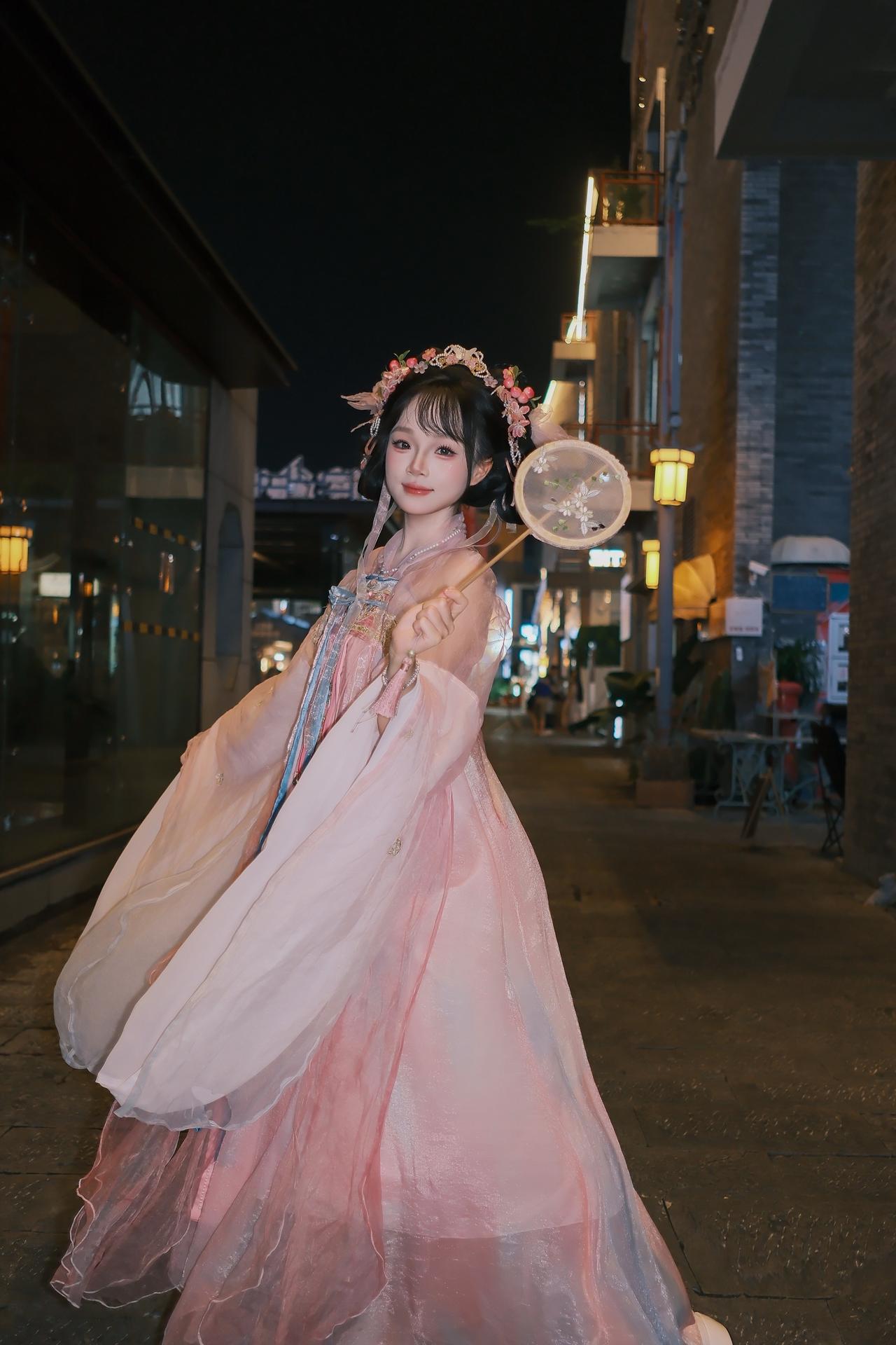 古镇，灯火辉煌的夜晚小姐姐独自来找我拍照。妆容精致，表情甜美，姿势柔和，边走边拍
