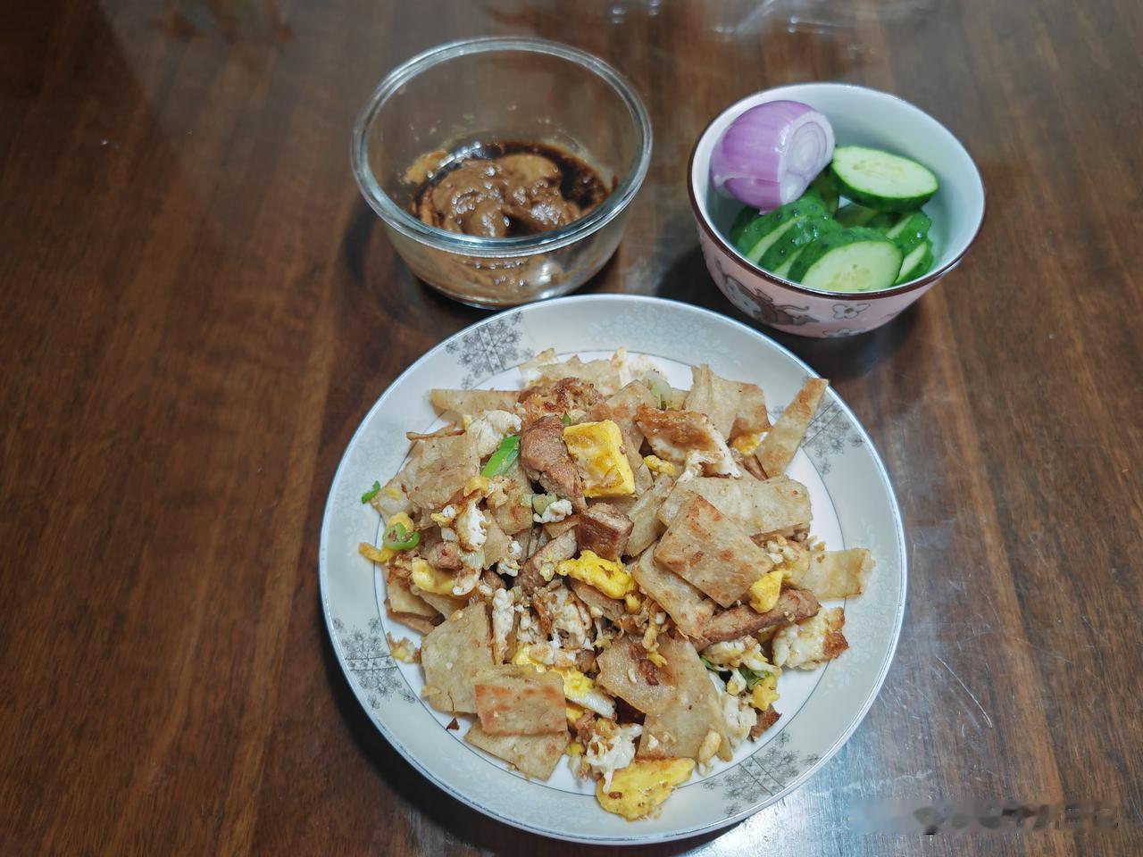 冰箱冷藏室里有三片剩饼，拿出来切成小块，还有冷冻盒里剩的一块猪大排，解冻后剔骨切