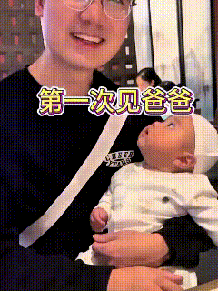 头一回见爸爸，小家伙就睁着圆溜溜的眼睛，直勾勾盯着看，模样呆萌得很。被爸爸抱起来
