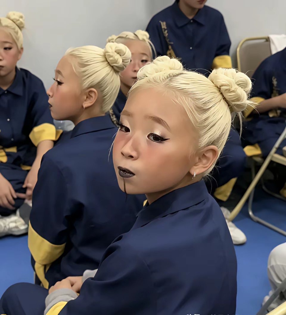 上海某培训机构的儿童舞蹈比赛上，五六岁的孩子被染了一头白发，画着黑色的眼线、黑色