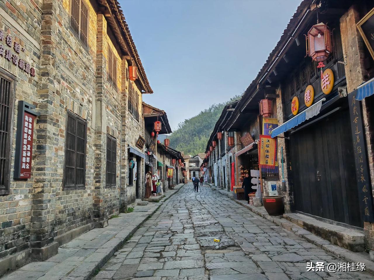 构图上，街道的延伸感把握得很好，引导视线。色彩丰富且协调，古建与招牌相映成趣。光
