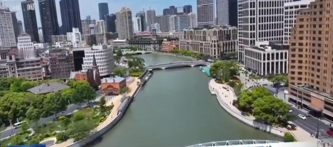 2026年积极财政政策聚力扩内需、惠民生，画面中城市河道两岸高楼林立，尽显都市发