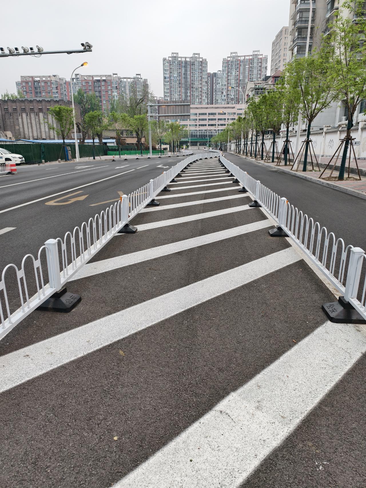 城市主城区并不宽的街道上，交通导流线几乎占去了一半，还用栏杆围着，对安全行车有多