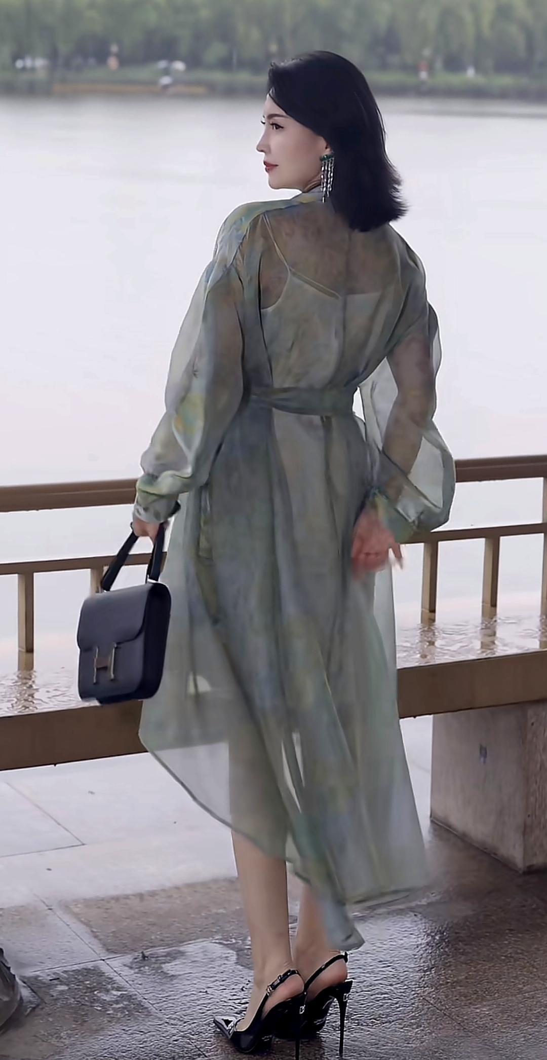 这位女士穿着漂亮的长裙在湖边散步，那画面简直美极了。就像70岁的赵雅芝，在湖边晒