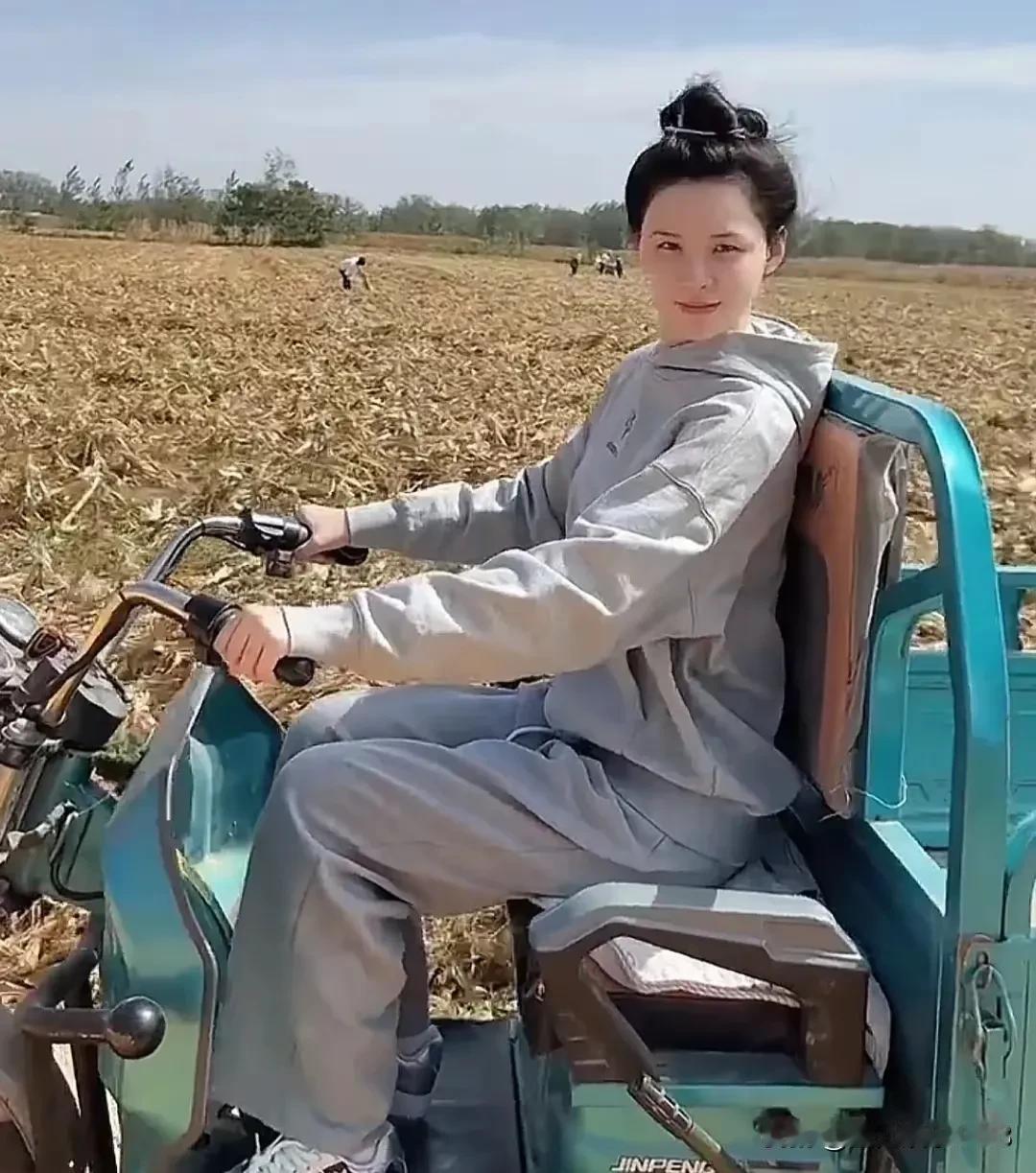 张颖颖国庆回村秋收，会骑三轮车，也能下地捡玉米，帮家人晒玉米，活脱脱一个农村娃。