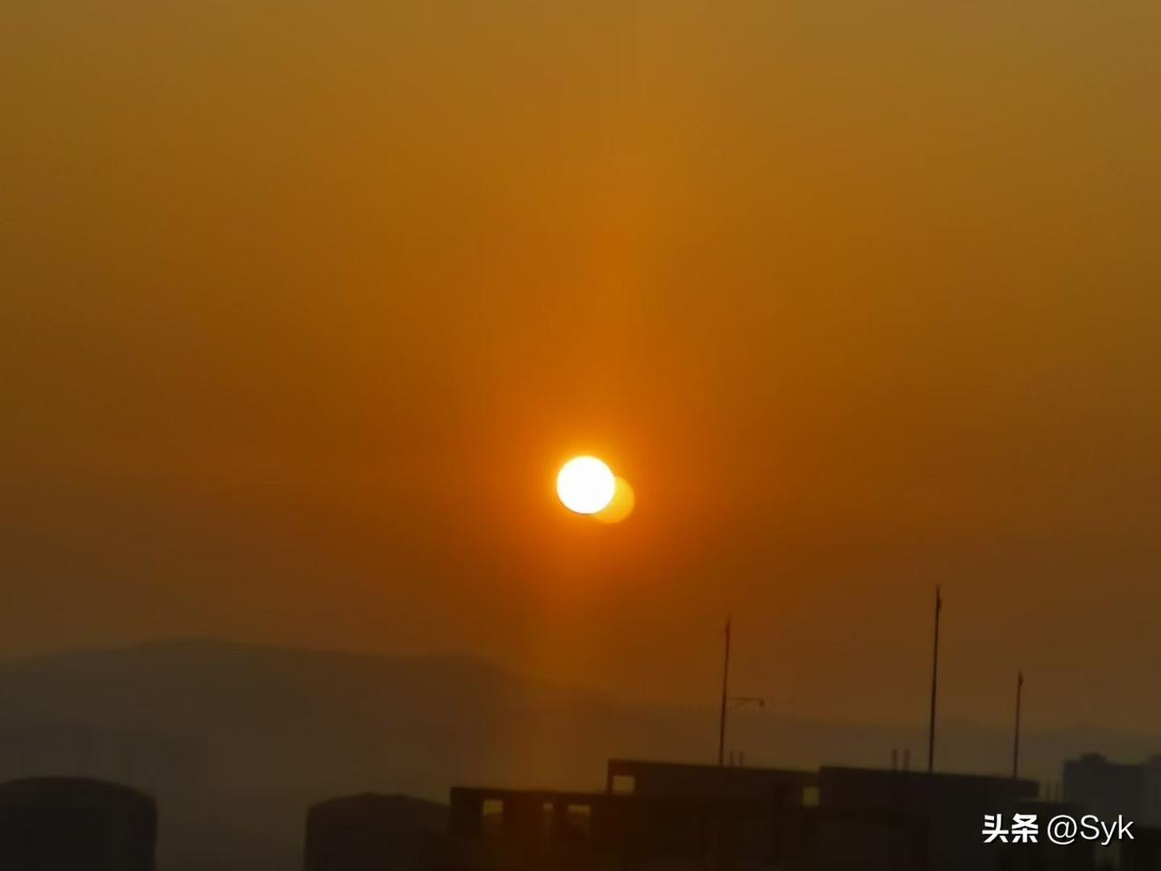 今早出门上班，
刚抬头就愣住了，
天空里竟像是挂着两个太阳，
光影交错，
难得一