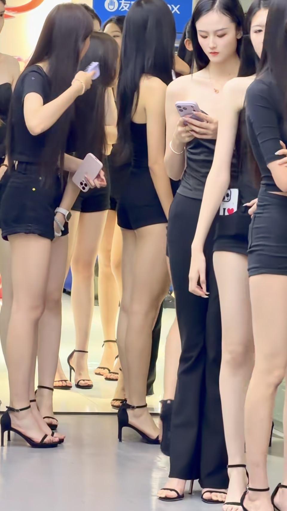 一群穿黑色衣服的女孩在逛街。