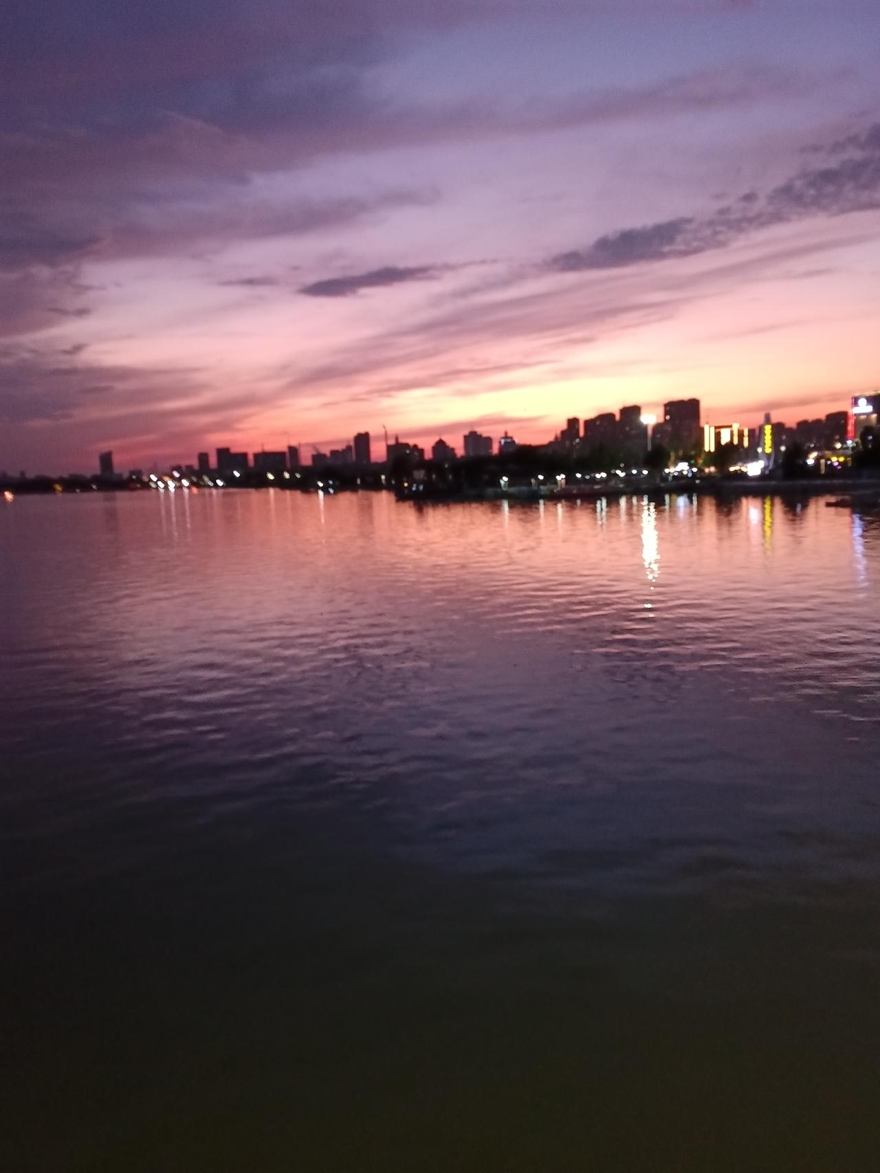 漫步北关桥，邂逅一场醉人的黄昏。夕阳缓缓靠近地平线，将整片天空晕染出柔和的橙粉之