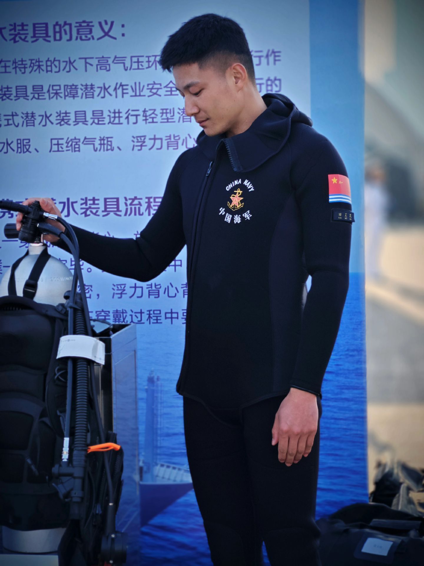 一身中国海军潜水服，胸前“CHINA NAVY 中国海军”徽章熠熠生辉，臂章上的