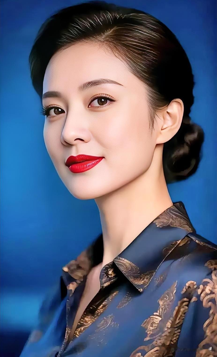 盘发雅致，深蓝华服映红唇，眉眼间藏着岁月沉淀的从容大气。
