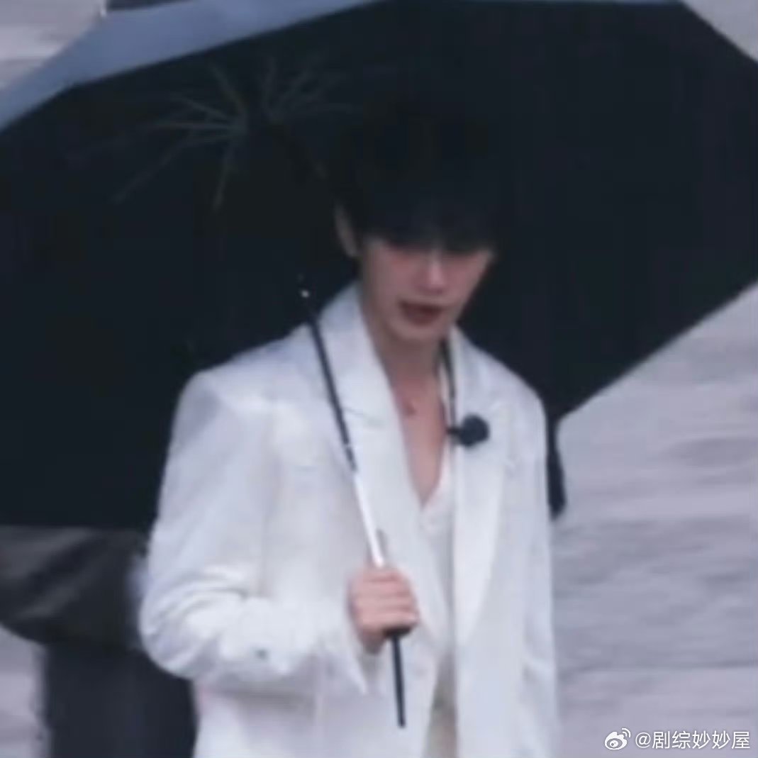 丁程鑫录制《开始推理吧》，一身白色西装在雨中撑伞，边走边和粉丝打招呼。那模样，像