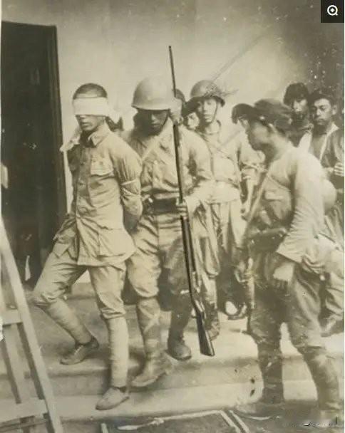 1937年，一名中国士兵被日军押往刑场。打着标准绑腿、穿着胶鞋，双眼被蒙、双手被