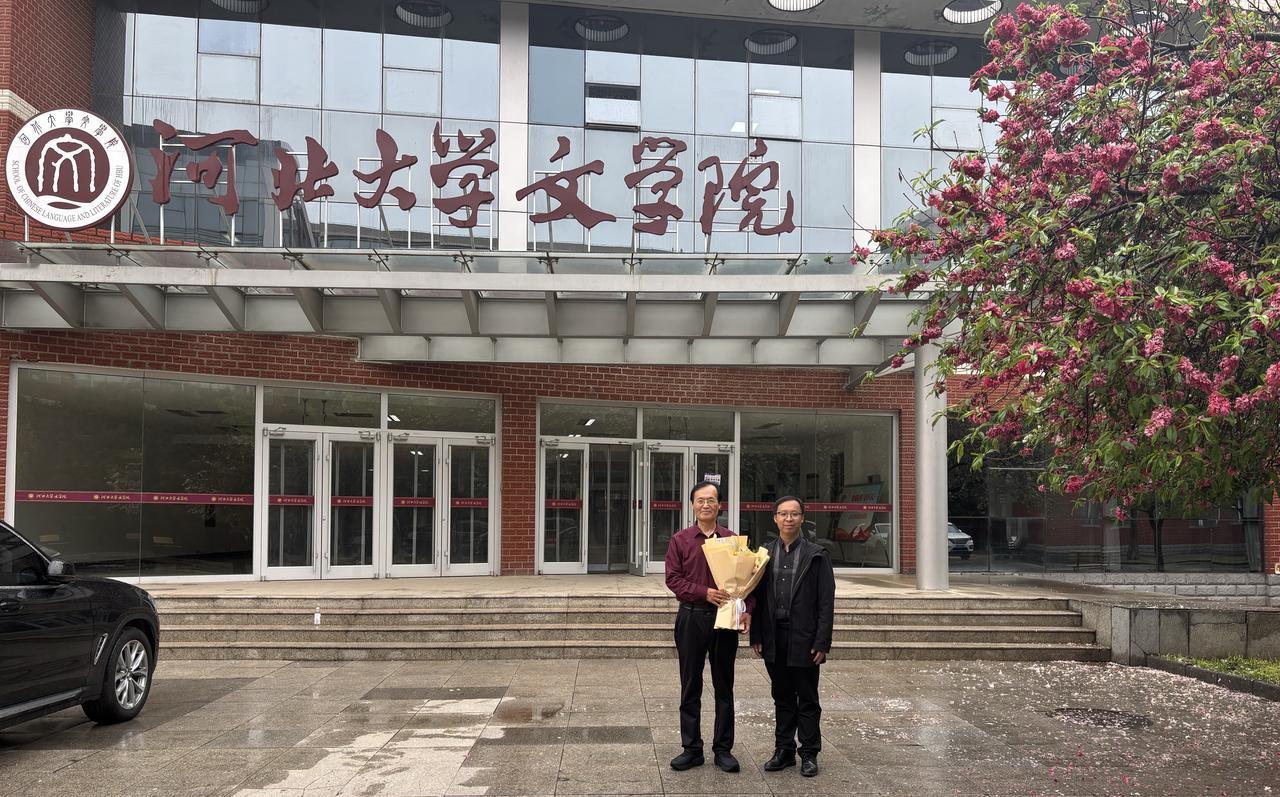 在河北大学文学院楼前，撒金碧桃树下，与文学院党委副书记陈寒光合影留念。