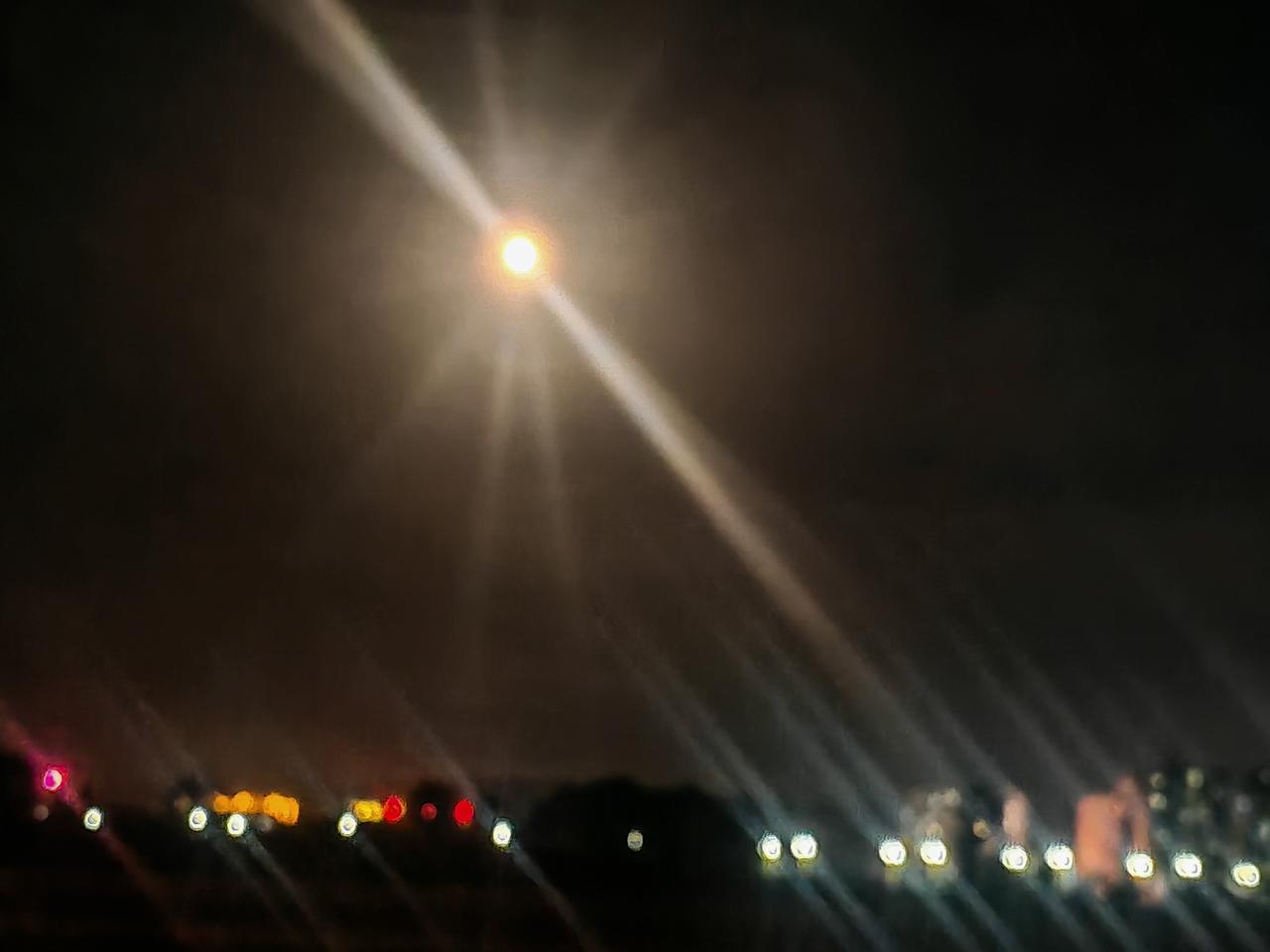 分享一张相册里随手拍的天空夜色沉沉，一轮圆月悬在墨色夜空，光晕漫出绵长放射状光带