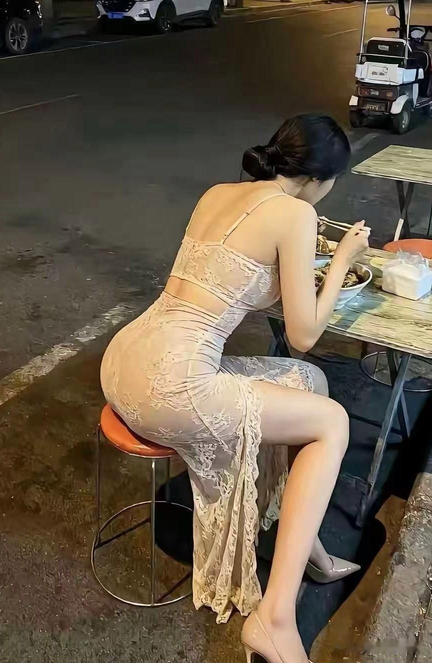 晚上散步路过街边夜排档，一下子被眼前画面吸引住了。一个女人穿着一身精致蕾丝长裙，