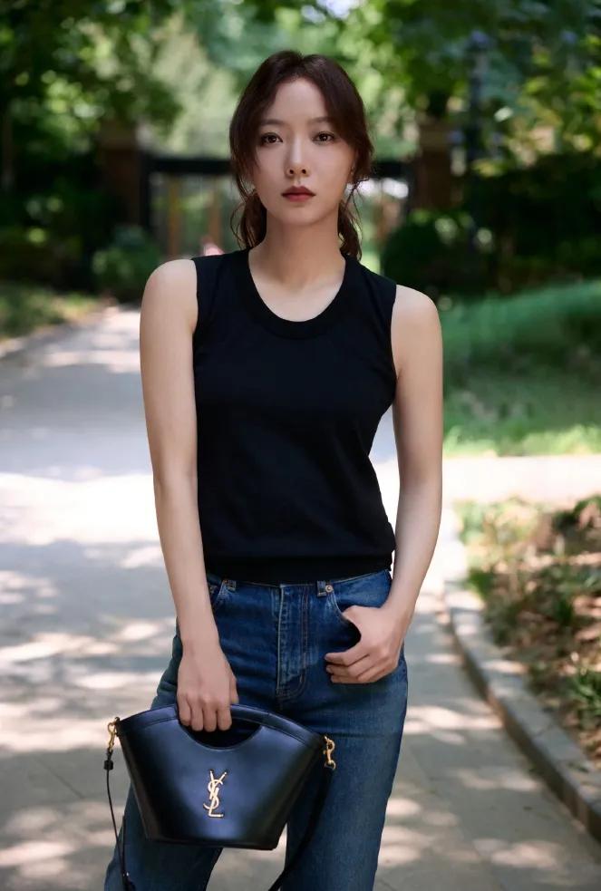 王珞丹极简私服太有高级感✨
基础黑无袖背心搭配高腰牛仔直筒裤
黑白蓝经典配色，慵