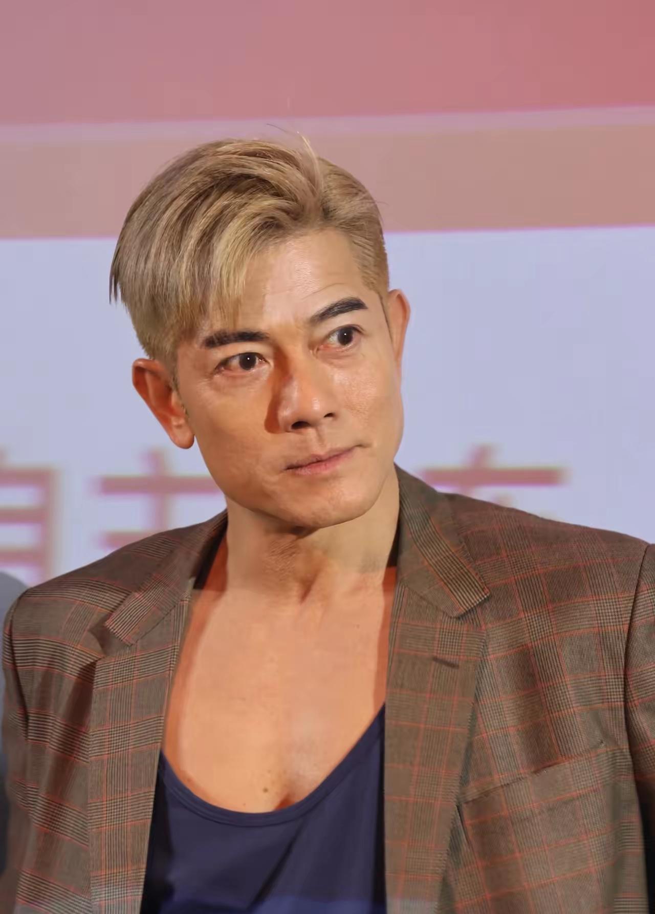 镜头中的郭富城金发炫目，张眉努眼，方颐大耳，鼻若悬胆，额纹清晰，颈纹明显，长脸薄