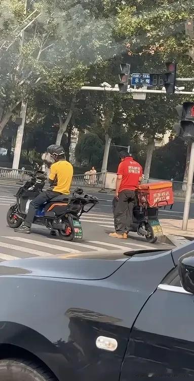 918警报响起的时候，两名外卖员都停下了车。不过美团的外卖员是坐着的，而京东的外