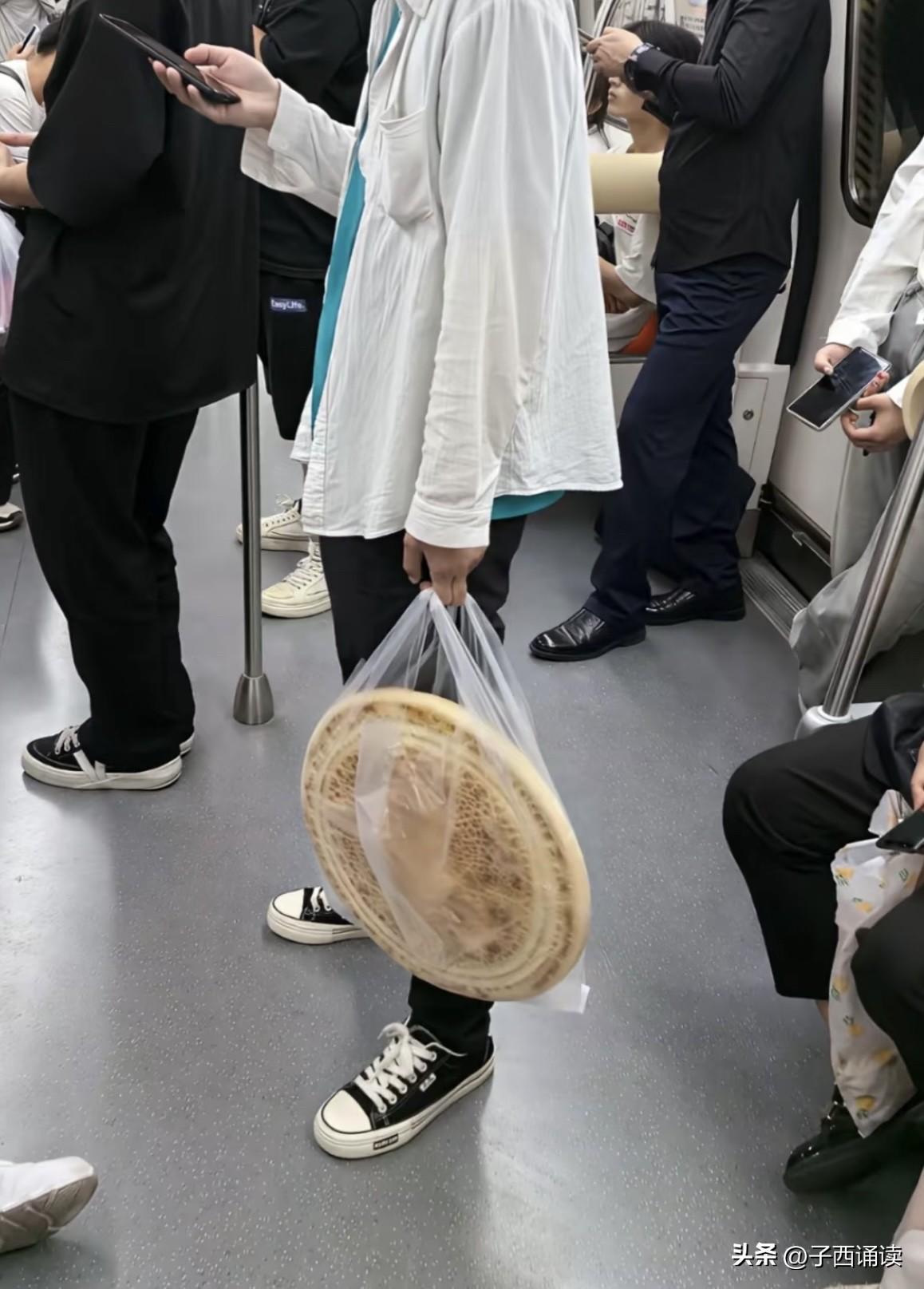 哈哈，昨天上班在地铁上看到的，小伙子拎的是武大郎炊饼吗？