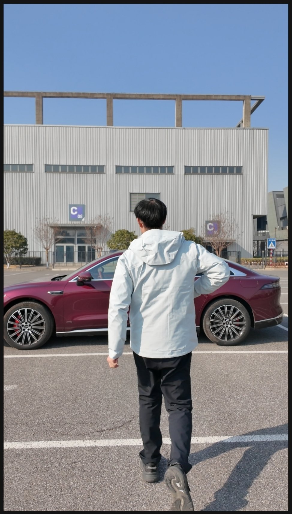 一位科技/汽车博主，大步流星的走向一辆汽车。 